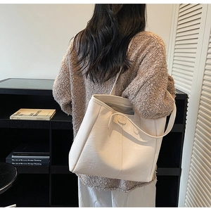 Dettaglio della borsa tote bianco opaco con texture in pelle liscia e fibbia metallica