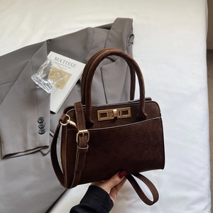 Detail of vintage coffee frosted leather handbag with gold twist lock and round handle