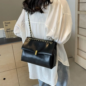 Borsa a tracolla classica in pelle nera con fibbia dorata in un ambiente moderno