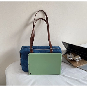 Blue denim shoulder bag with brown leather straps shown with a tablet for size reference