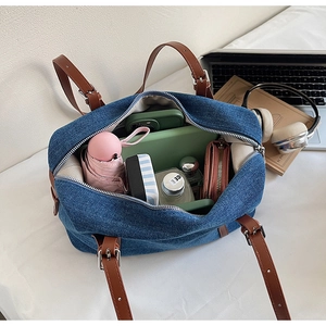 Top view of large capacity denim bag interior showing daily items and leather straps