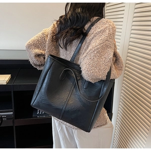 Dettaglio della borsa tote nera in pelle PU vintage con doppie tracolle in casa