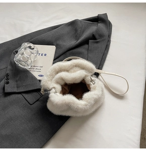 Detail of soft white faux fur bucket bag with drawstring and brown fabric lining