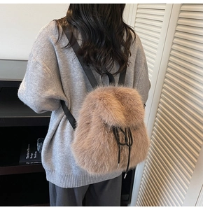 Detail showing plush faux fur texture and black straps on a khaki backpack