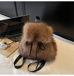 Detail of plush brown faux fur backpack featuring a black drawstring and soft texture