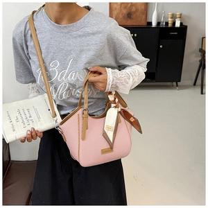 Pink woven tote bag featuring brown leather straps and a decorative floral silk scarf detail