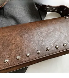 Detail shot of brown lychee-textured faux leather bag with silver metal rivets accents