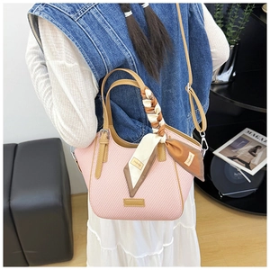 Pink woven tote bag with brown leather handles and a decorative fashion scarf detail