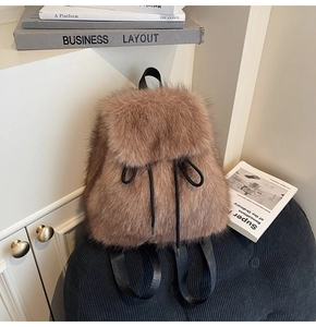 Close-up of brown faux fur backpack with black drawstring and cozy autumn textures