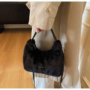Detail of black faux fur handbag with love every day gold label and soft texture