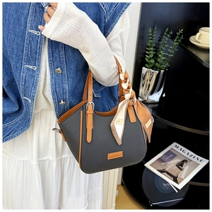 Close-up of contrast color handbag with black carbon fiber texture and silk scarf handle
