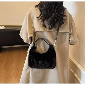 Detail of plush black handbag featuring leather love label and silver hardware