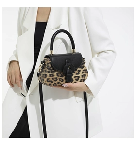 Vue détaillée du sac bandoulière léopard avec rabat en cuir noir sur blazer blanc