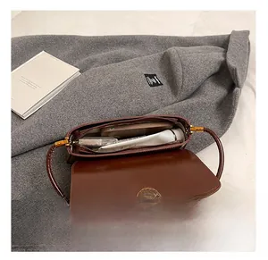 Internal capacity of brown leather baguette bag with phone and cosmetics inside