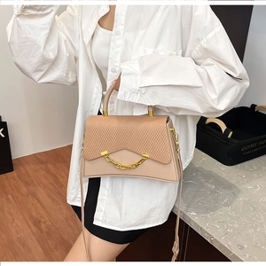 Détail du sac à main beige avec rabat tissé et ornement de chaîne dorée élégante