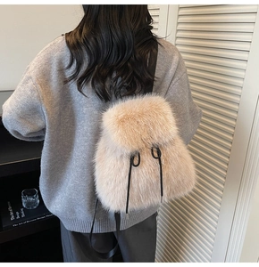 Detail view of cream plush faux fur backpack with black drawstring on model’s back
