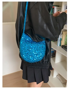 Detailansicht der blauen Pailletten-Umhängetasche kombiniert mit einer Lederjacke