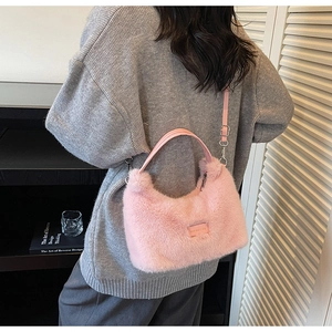 Pink plush faux fur tote bag featuring a leather handle and adjustable shoulder strap