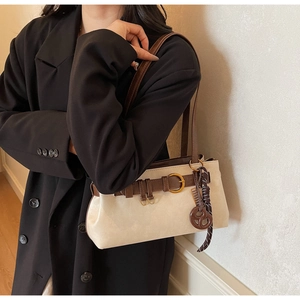 Detail of Boston underarm bag with decorative pretzel charm and gold hardware accents