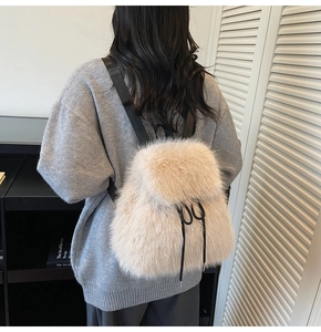 Detail of plush faux fur backpack in beige with black drawstring and textile straps