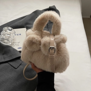 Plush faux fur bucket bag in apricot beige with a decorative bow and leather strap