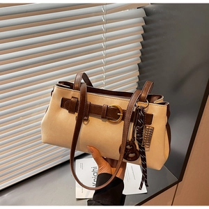 Detail of retro cream leather Boston bag with brown straps and golden buckle hardware