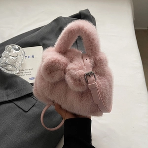 Pink plush bucket bag with a faux fur bow and adjustable leather shoulder strap