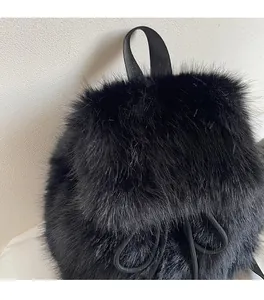 Detailed close-up showing soft black faux fur texture and drawstring of the backpack