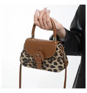 Vue détaillée du sac bandoulière léopard avec rabat en cuir brun et finitions dorées