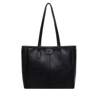 Borsa tote nera classica con trama litchi e tracolle sottili su sfondo bianco neutro