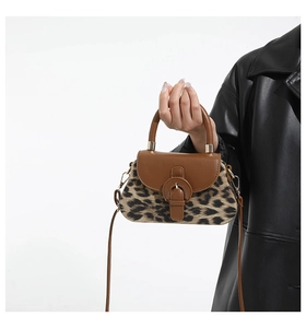 Détail du sac léopard avec bandoulière en cuir marron et boucle dorée en métal