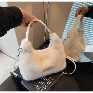 Detail of soft cream faux fur handbag with leather handle and love every day tag