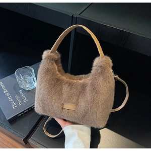 Detail of plush faux fur handbag with leather handle and 'love every day' patch