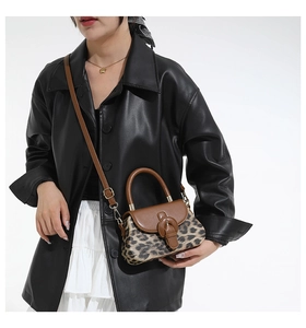 Détail du sac bandoulière léopard avec rabat en cuir marron et poignée ronde