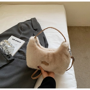 Detail of plush beige faux fur handbag on white bedding with a luxury fashion aesthetic
