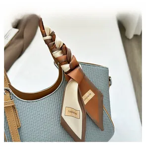 Close-up of brown silk scarf with FASHION text wrapped on handbag handle