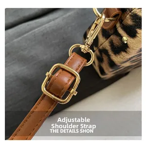 Détail d'un sac bandoulière léopard avec bandoulière réglable en cuir marron et boucle or
