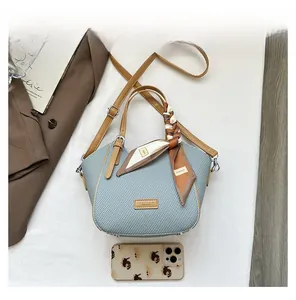 Light blue woven handbag with brown PU straps and decorative scarf on a white background