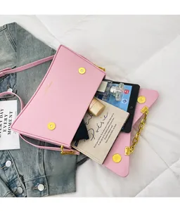 Sac bandoulière rose rectangulaire montrant l'intérieur spacieux pour accessoires