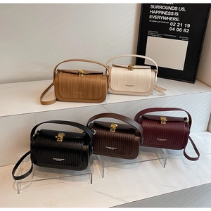 Five vintage leather crossbody bags in various colors with woven flap details and gold buckles