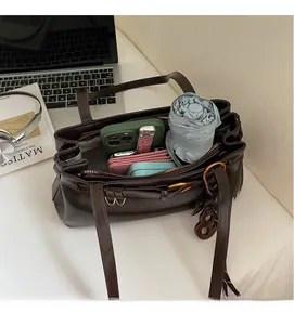 Deep brown Boston bag showing large interior capacity with phone, wallet and umbrella