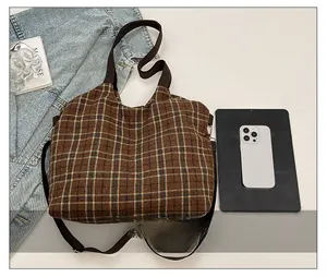 Brown plaid tote bag size comparison with tablet and smartphone on denim jacket