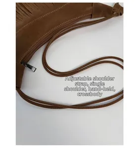 Détails de la bandoulière réglable et du zip sur le sac en daim marron à franges