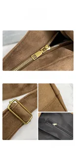Detail view of brown suede shoulder bag showing gold zippers and adjustable strap