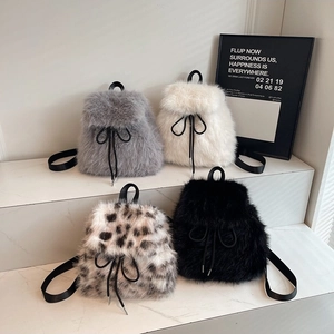 Mini plush backpacks in four colors featuring faux fur texture and black drawstring bows