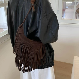 Détail d'un sac à bandoulière en daim mat marron foncé avec franges style bohème