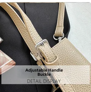 Detail view of beige lychee leather strap with adjustable silver metal buckle on handbag
