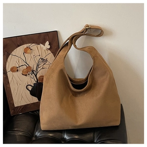 Detailed macro view of caramel suede hobo bag with adjustable strap and gold hardware