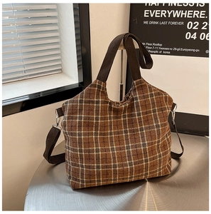 Detail of vintage brown plaid canvas tote bag with thick handles and adjustable strap
