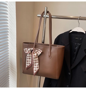 Brown faux leather tote bag detail with houndstooth scarf and long shoulder strap